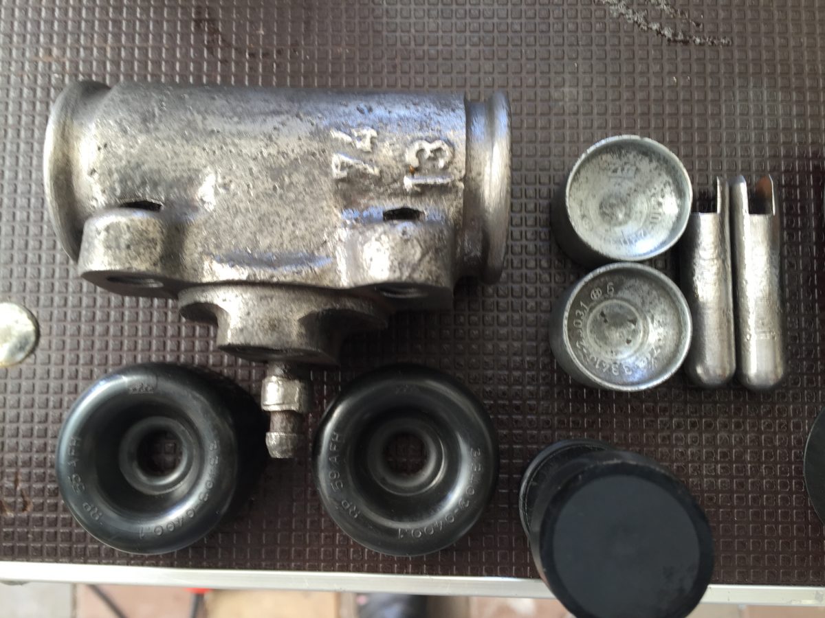 Cleaning up both rear brake cylinders, removing rust, cleaning pistons